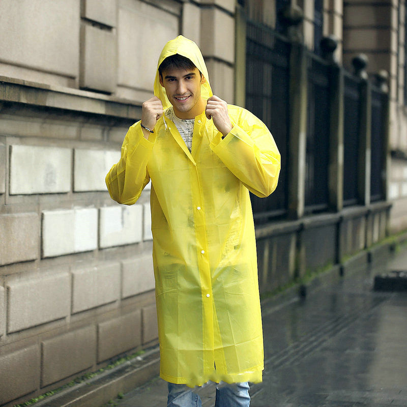 EVA Raincoat for Adults in Yellow. The young man is wearing the raincoat, walking down a rainy street.