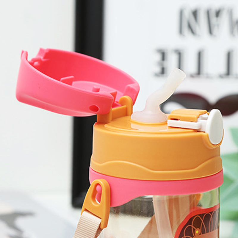 Colorful water bottle with pink and orange lid and straw on a blurred background