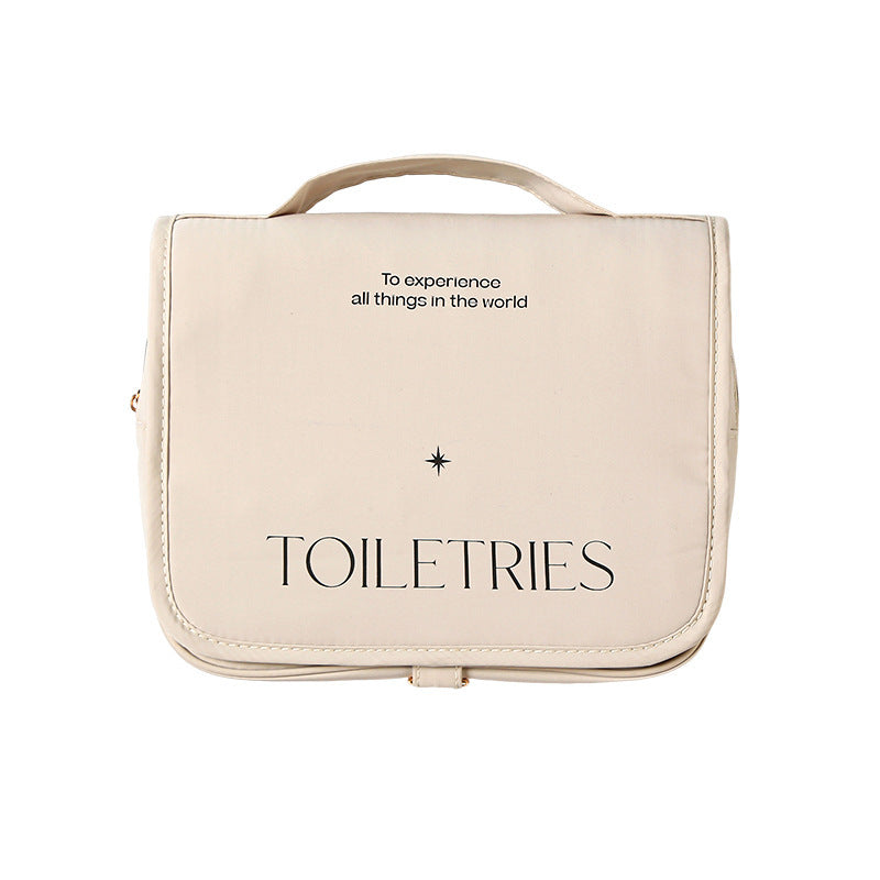 This is an image of the cream toiletries bag on a white background. it shows the word in black Toiletries, the star above it and the words to experience all things in the world.