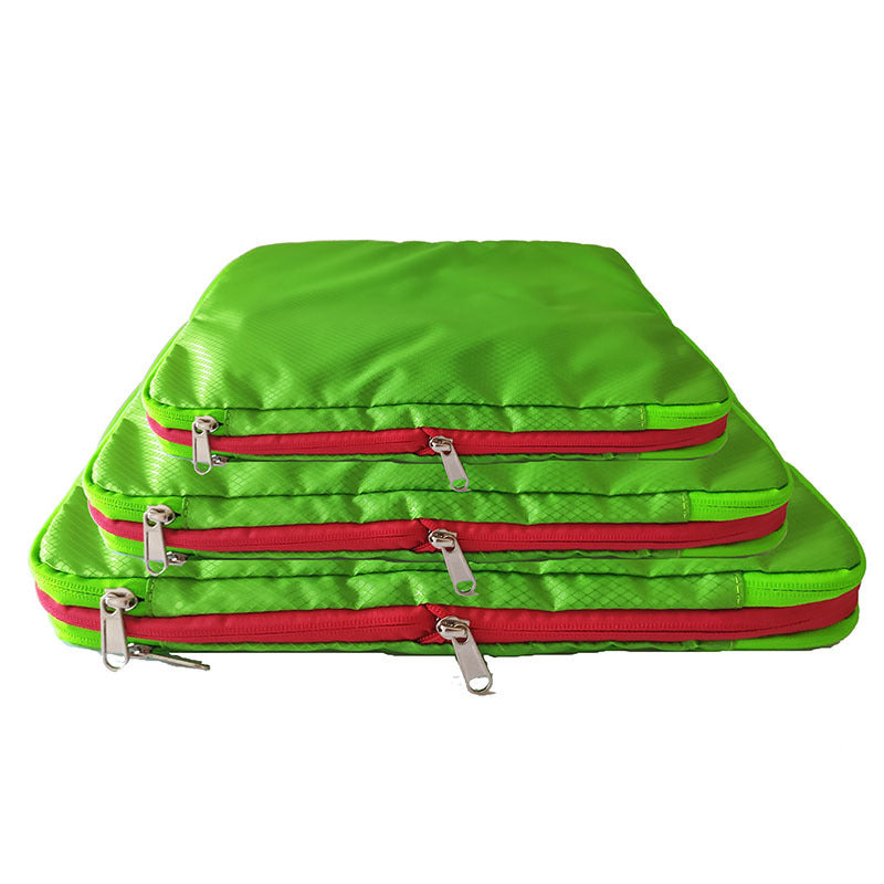A set of 3 Compression Packing Cubes stacked on top of each other in smal, medium and large. They are bright green with red zipper, they are rectangular shaped