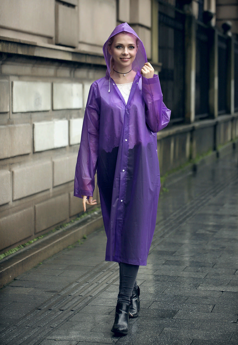 EVA Raincoat for Adults in Purple. The young woman is wearing the raincoat, walking down the street