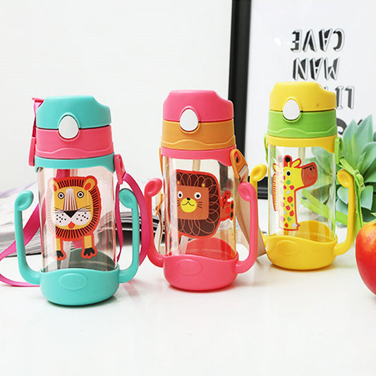 Three colorful children's water bottles with animal designs on a white surface. The animal designs are tiger and the cup is light blue with pink collar and pink lanyard. The Lion Bottle is pink with a beige collar and lanyard. The Giraffe cup is yellow with a green collar and lanyard.
