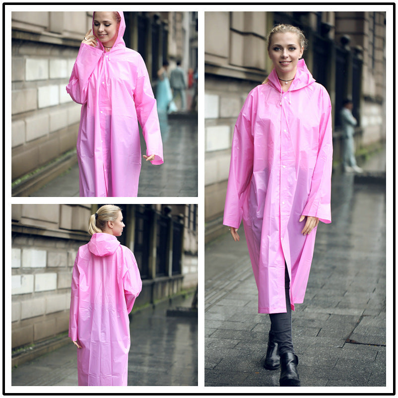 EVA Raincoat for Adults in Pink. The young woman is wearing the raincoat, walking through a rainy street in England Uk