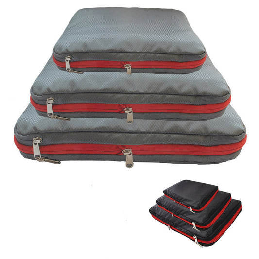 A set of 3 Compression Packing Cubes stacked on top of each other in small, medium and large. They are Grey with red zipper, they are rectangular shaped.