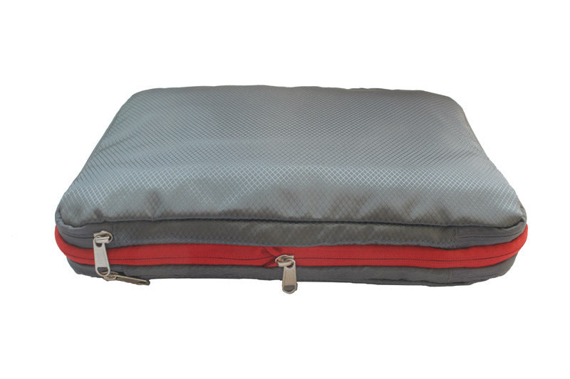 A Single Compression Packing Cube in grey with red zipper, it is rectangular shaped.