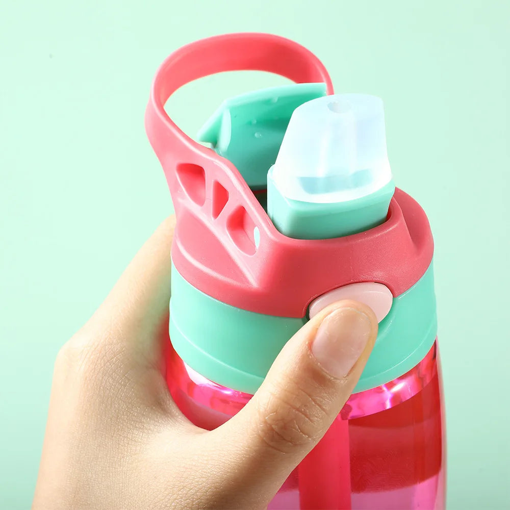 This image shows a close up of the straw and a thumb on the push button, you can also see the sturdy cup handle