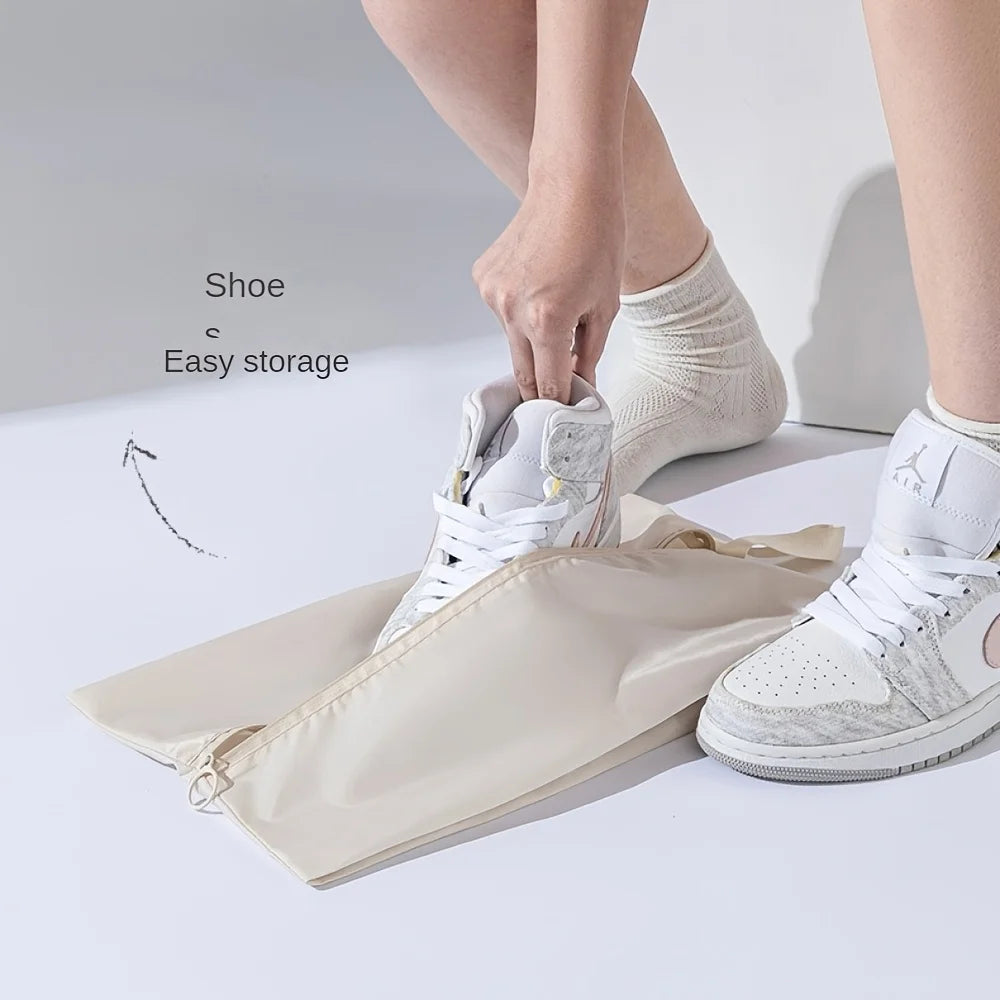 Person putting a shoe into a beige shoe storage bag with text 'Shoe Easy storage'.