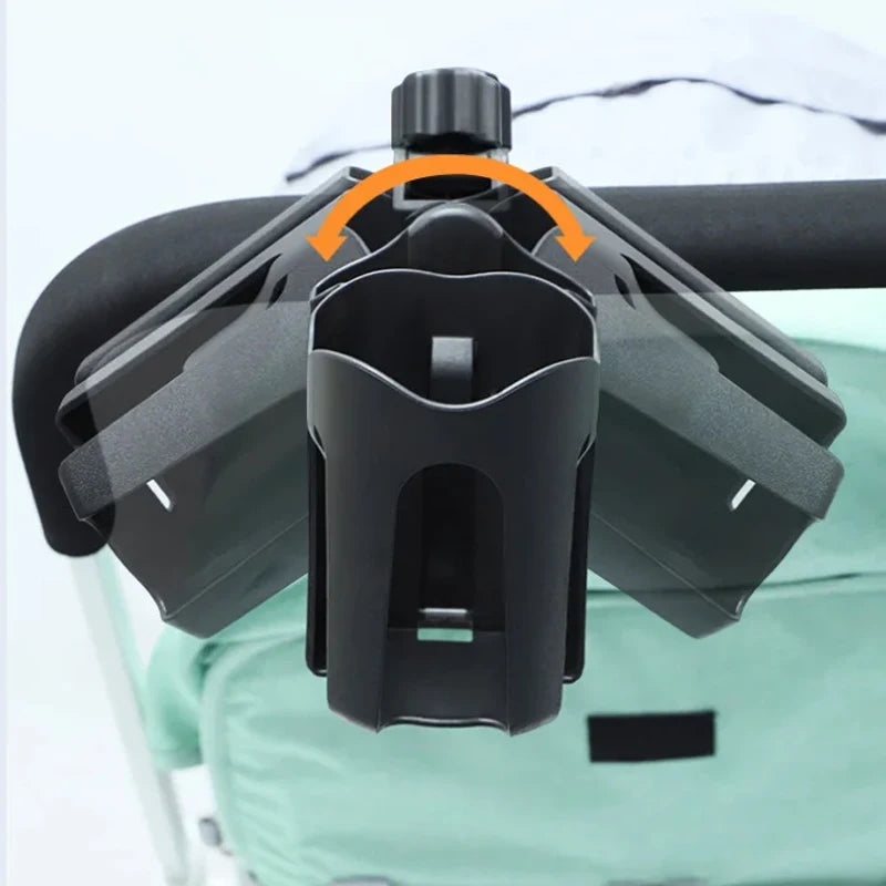 Close-up of a black cup holder attached to a childs stroller showing with an orange arrow that the cup holder swivles.
