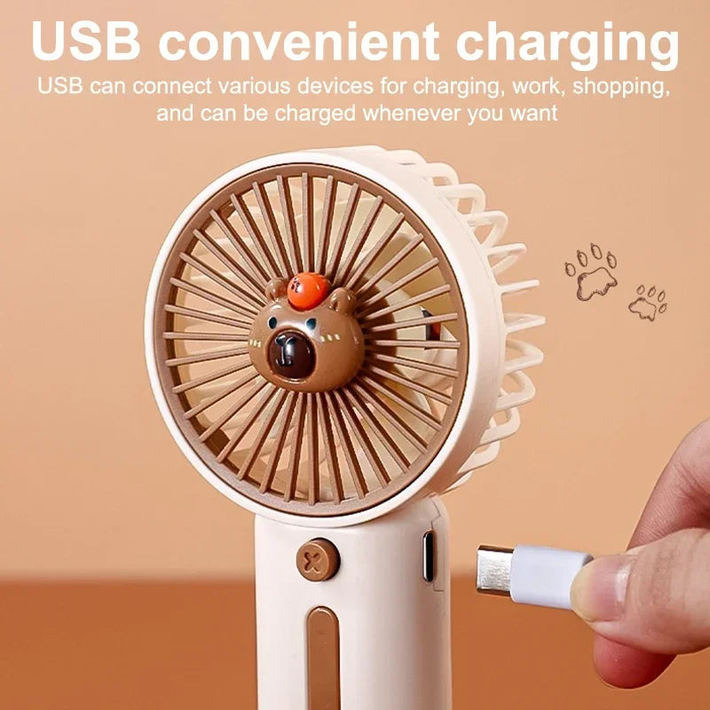 A charger is being plugged into the white hand held fan