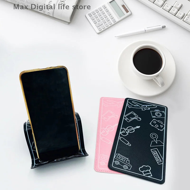 Phone stand with phone, pink and black phone holders flat on a desk with coffee and calculator.