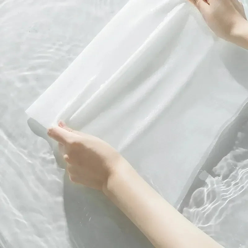 Person holding a white sheet over a textured surface