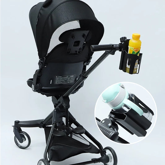 Black baby stroller with cup holder attachment on a light gray background