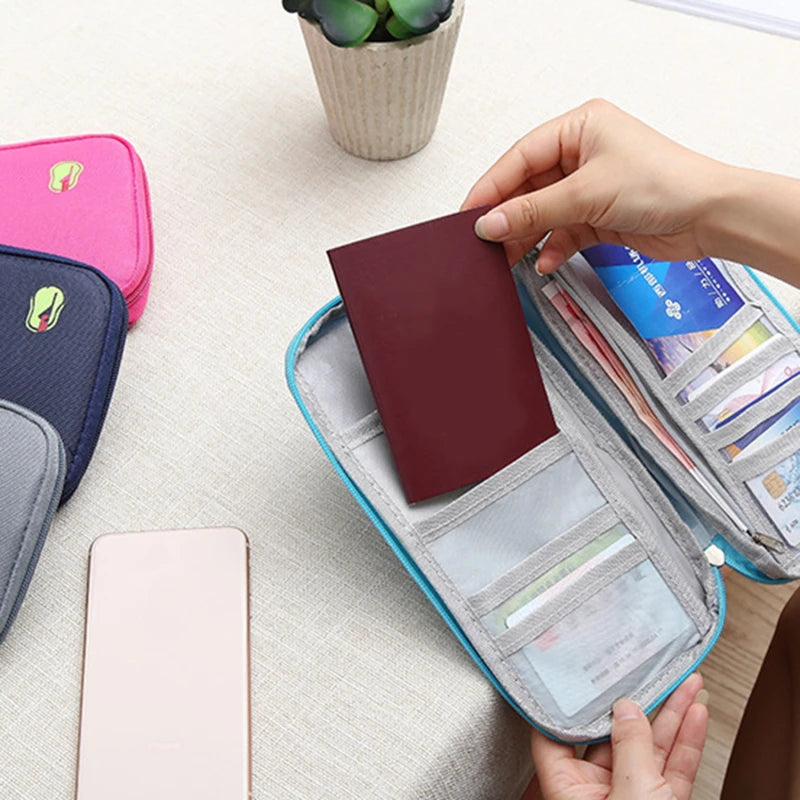 travel wallet organiser is open and a hand is putting a passport in one of the pockets