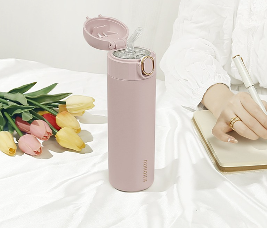 This is the Light su Pink Aurora Bottle sitting on a table with the flip lid open revealing the built in transparent straw.