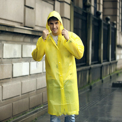 EVA Raincoat for Adults in Yellow. The young man is wearing the raincoat, walking down a rainy street.