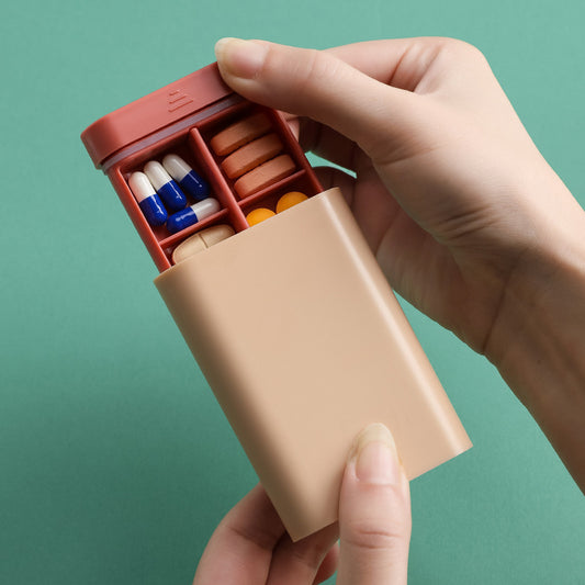 lady holding the pink box and has pulled out the tray to show square shaped bays for your tablets/pills/meds
