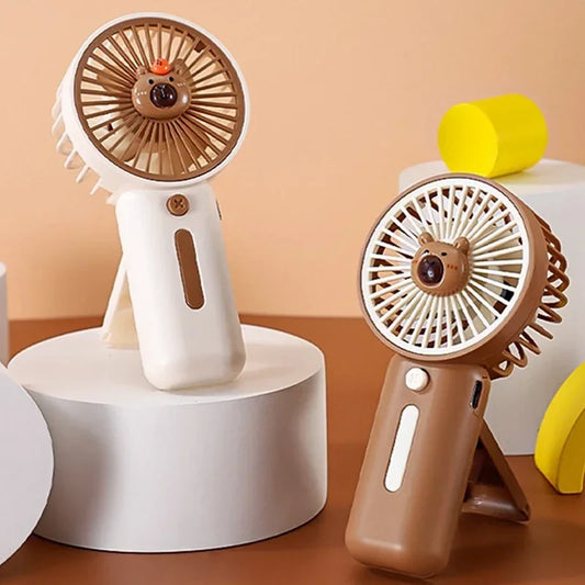 Compact Capybara-themed handheld USB fan one is white the other brown - perfect for travel or theme park use