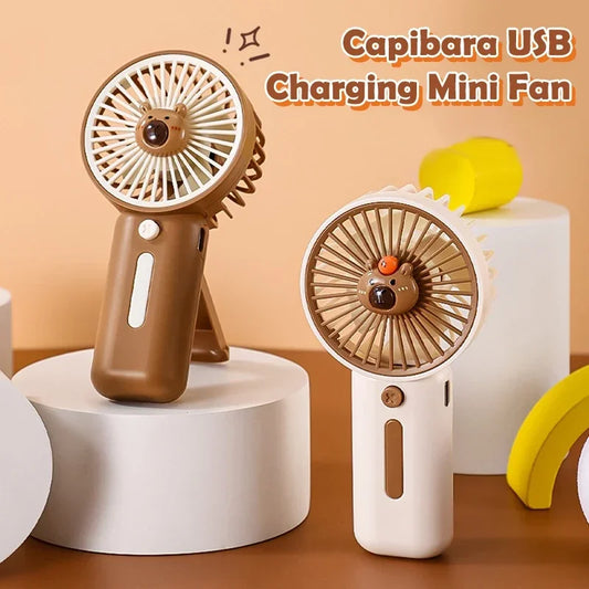 Compact Capybara-themed handheld USB fan one is white the other brown
 – perfect for travel or theme park use