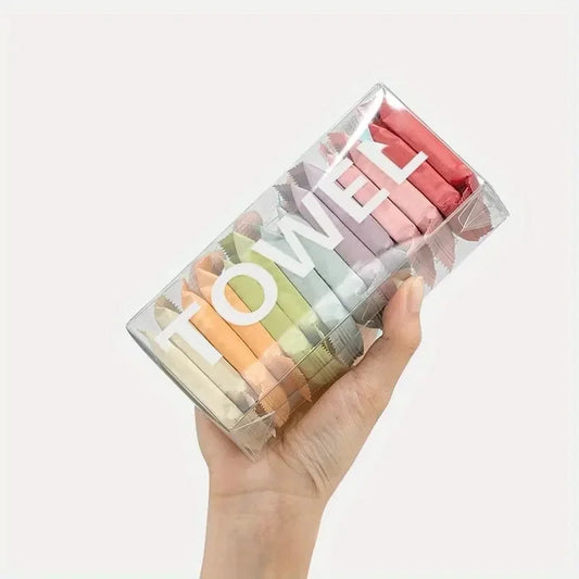 Hand holding a box of colorful individually wrapped compressed travel towels.