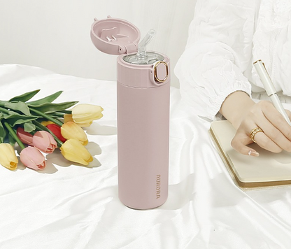 This is the Light su Pink Aurora Bottle sitting on a table with the flip lid open revealing the built in transparent straw.